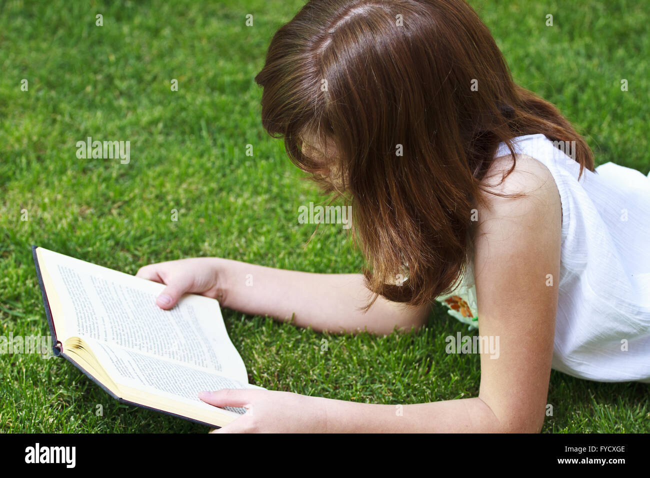 Young beautiful girl reading a book outdoor Stock Photo - Alamy
