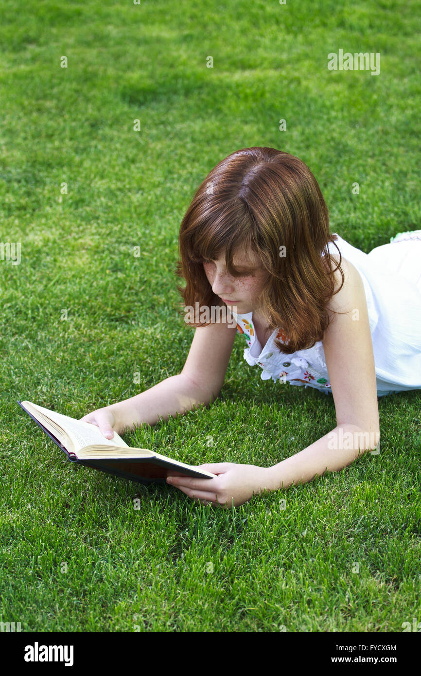 Young beautiful girl reading a book outdoor Stock Photo