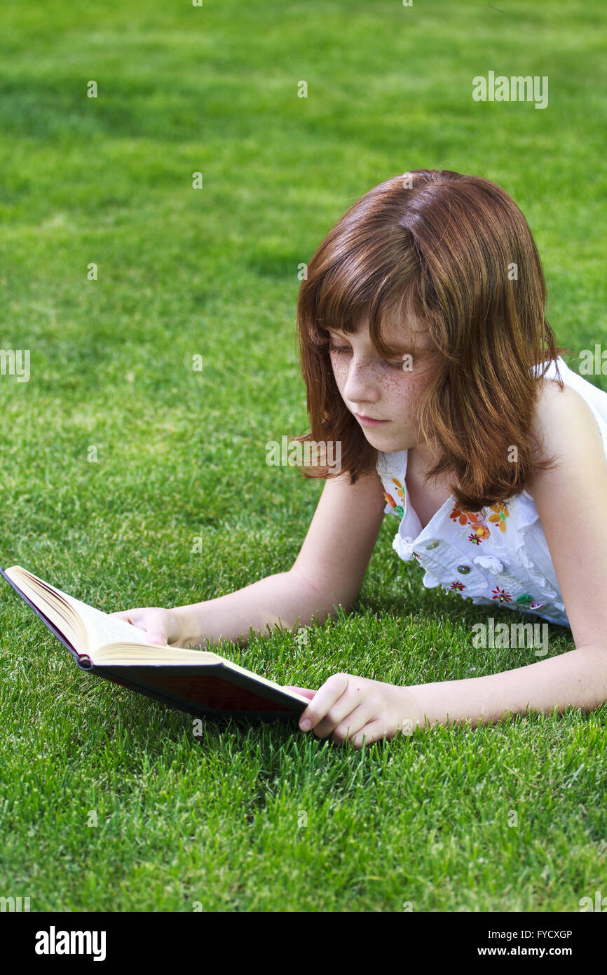 Young beautiful girl reading a book outdoor Stock Photo - Alamy