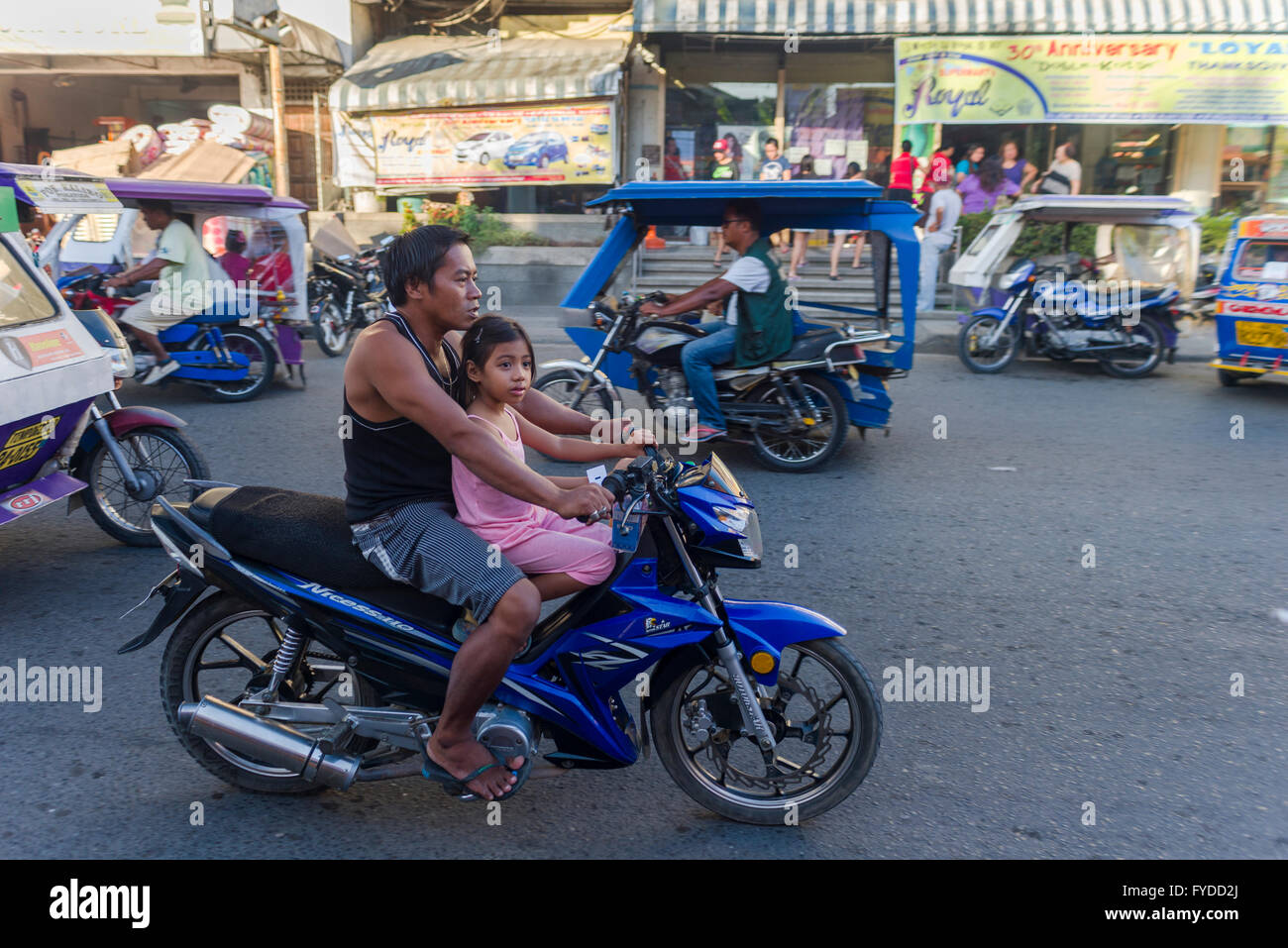 Iloilo, Philippines - February 13, 2016. Motorcycle transport in Iloilo Philippines. Father and daughter on the motorcycle and t Stock Photo