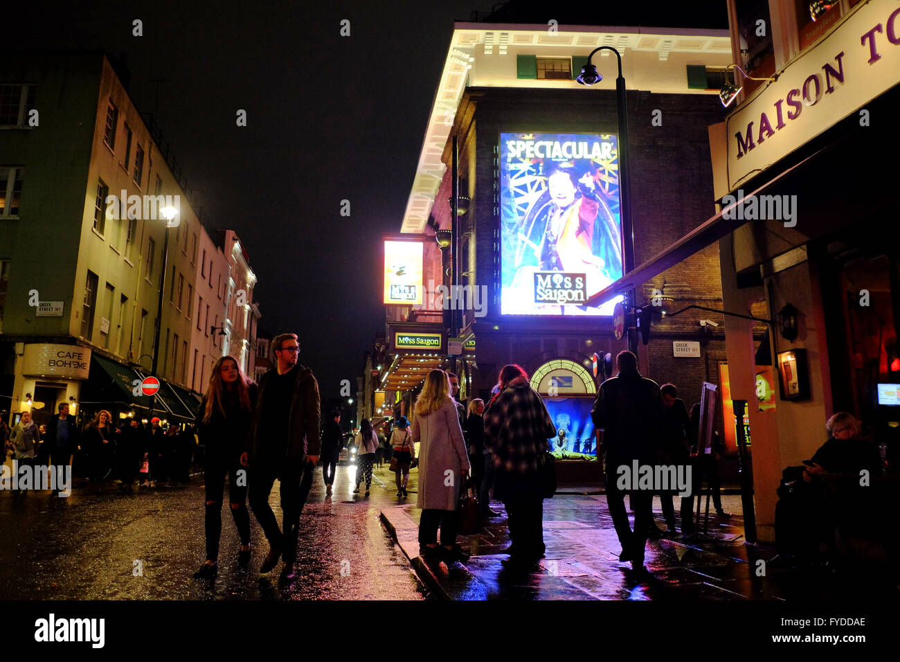 Prince Edward Theater showing Miss Saigon at night surrounded by bars and Cafés with people enjoying a night out in Soho, London Stock Photo