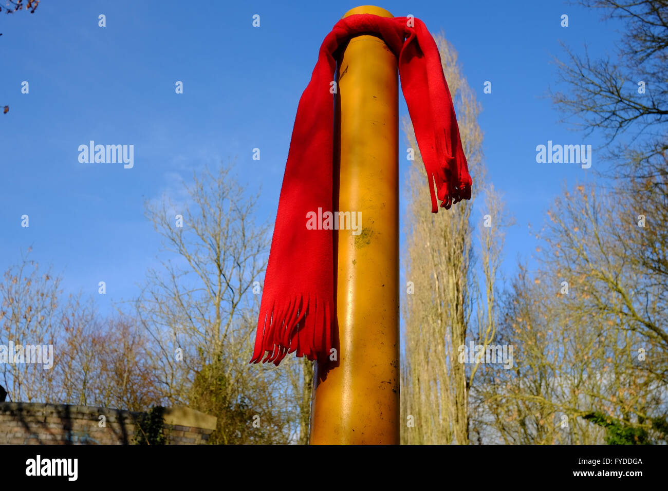 Red woolen scarf left tied to a bollard Stock Photo