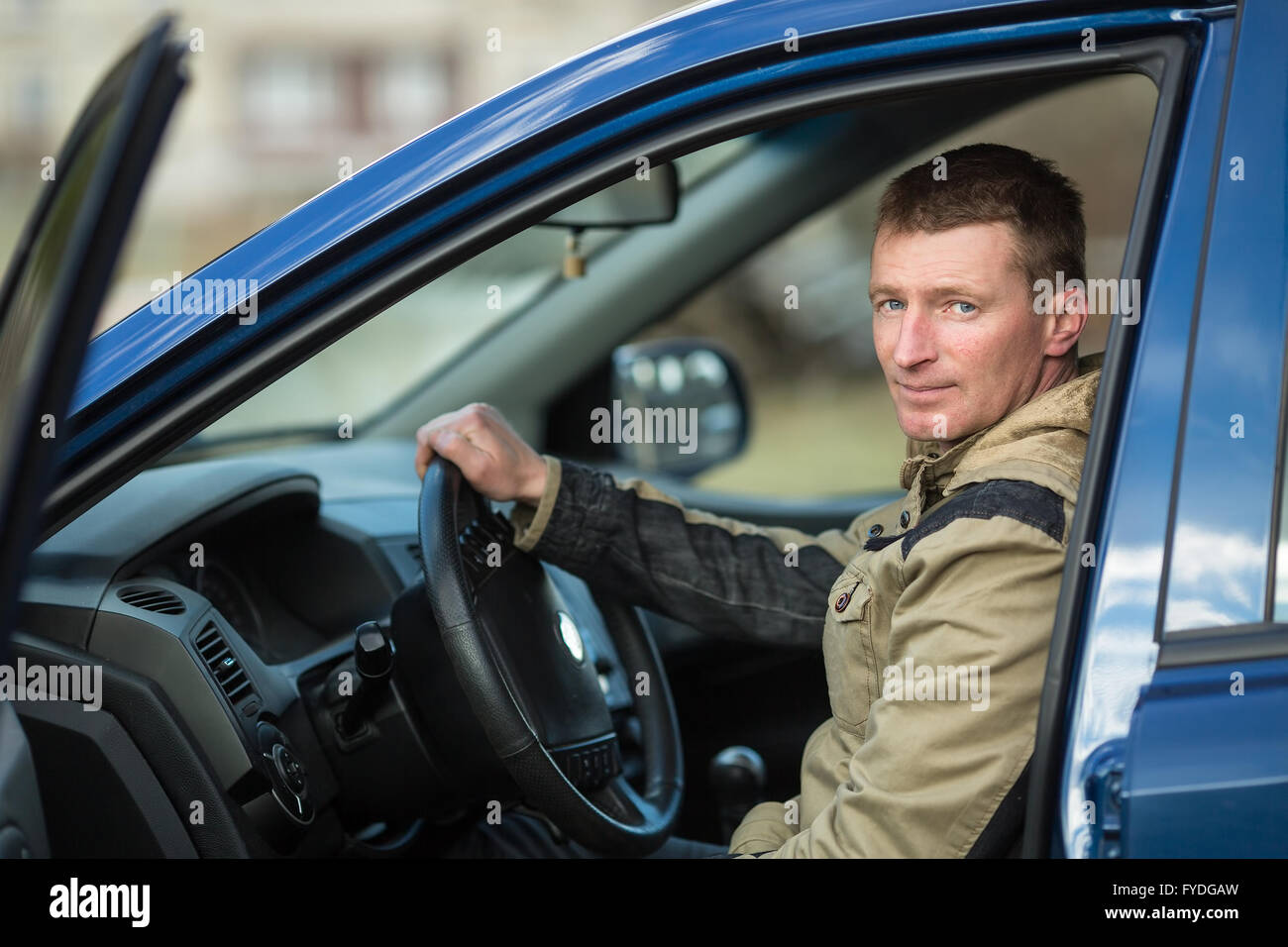 Young man driving a new car. Stock Photo