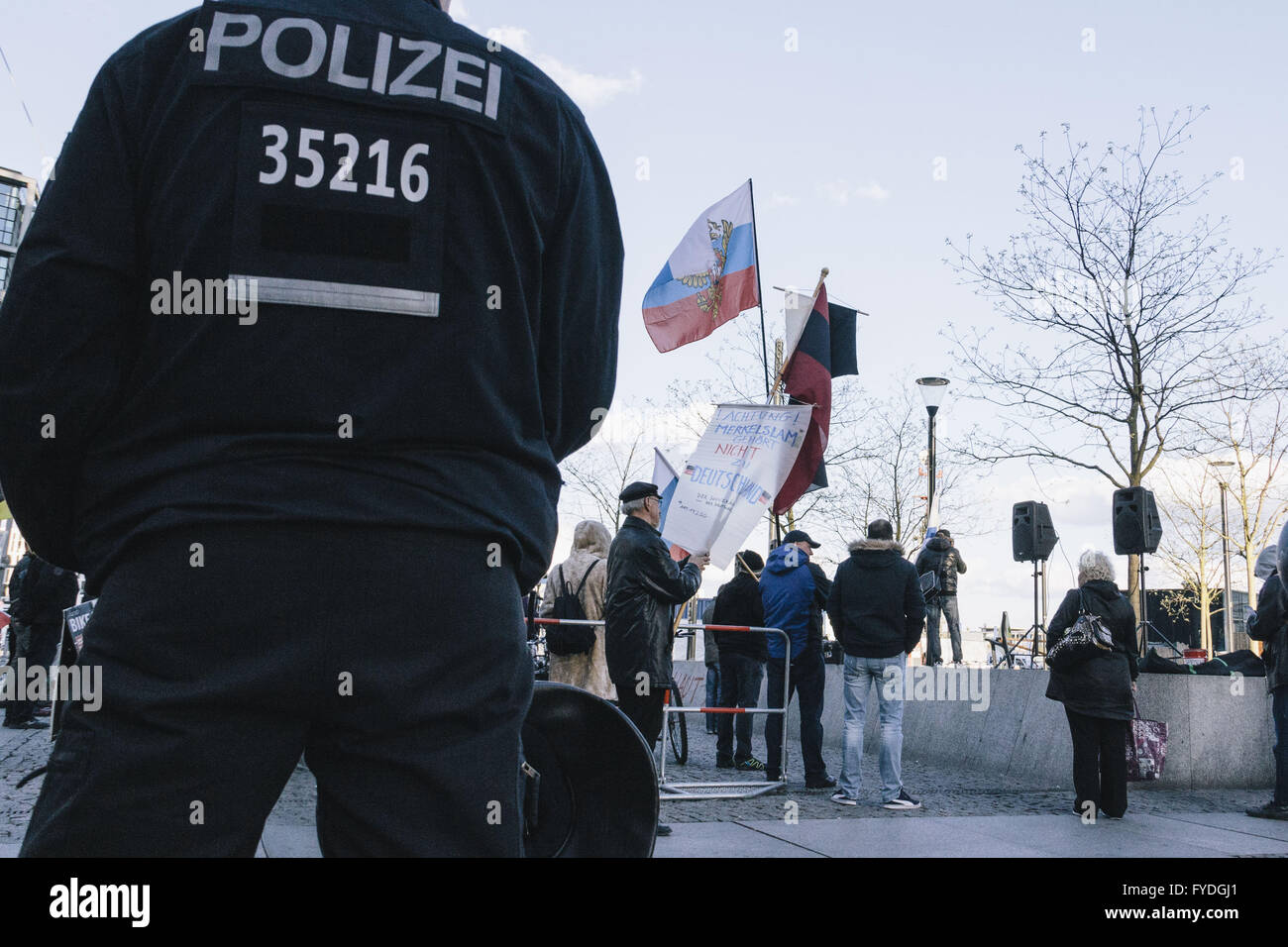 Berlin, Berlin, Germany. 25th Apr, 2016. Protesters behind a policeman during the right-wing Baergida Rally in front of Berlin Central Station. Baergida, an Anti-Islamic, anti-immigration, far-right movement meet for the 69th time since their first rally in January 2015. © Jan Scheunert/ZUMA Wire/Alamy Live News Stock Photo