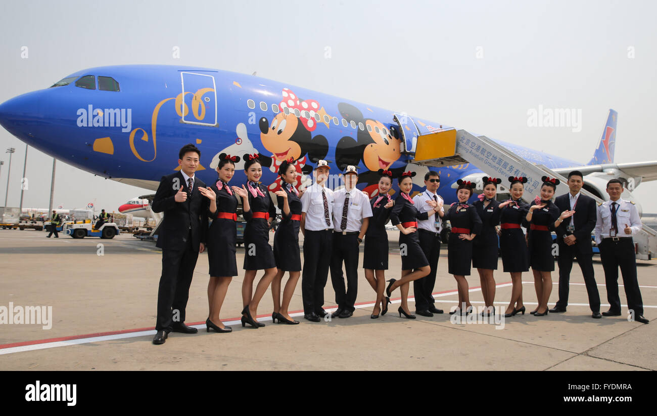 Beijing, China. 26th Apr, 2016. Crew members of China Eastern Airlines pose for a group photo with a plane which is painted with Disney figures in Beijing, capital of China, April 26, 2016. The Shanghai-based China Eastern Airlines prepares to put six Disney aircrafts into market before 2020. The Shanghai Disney Resort, Disney's first theme park on the Chinese mainland, is expected to open to the public on June 16. Credit:  Pei Xin/Xinhua/Alamy Live News Stock Photo