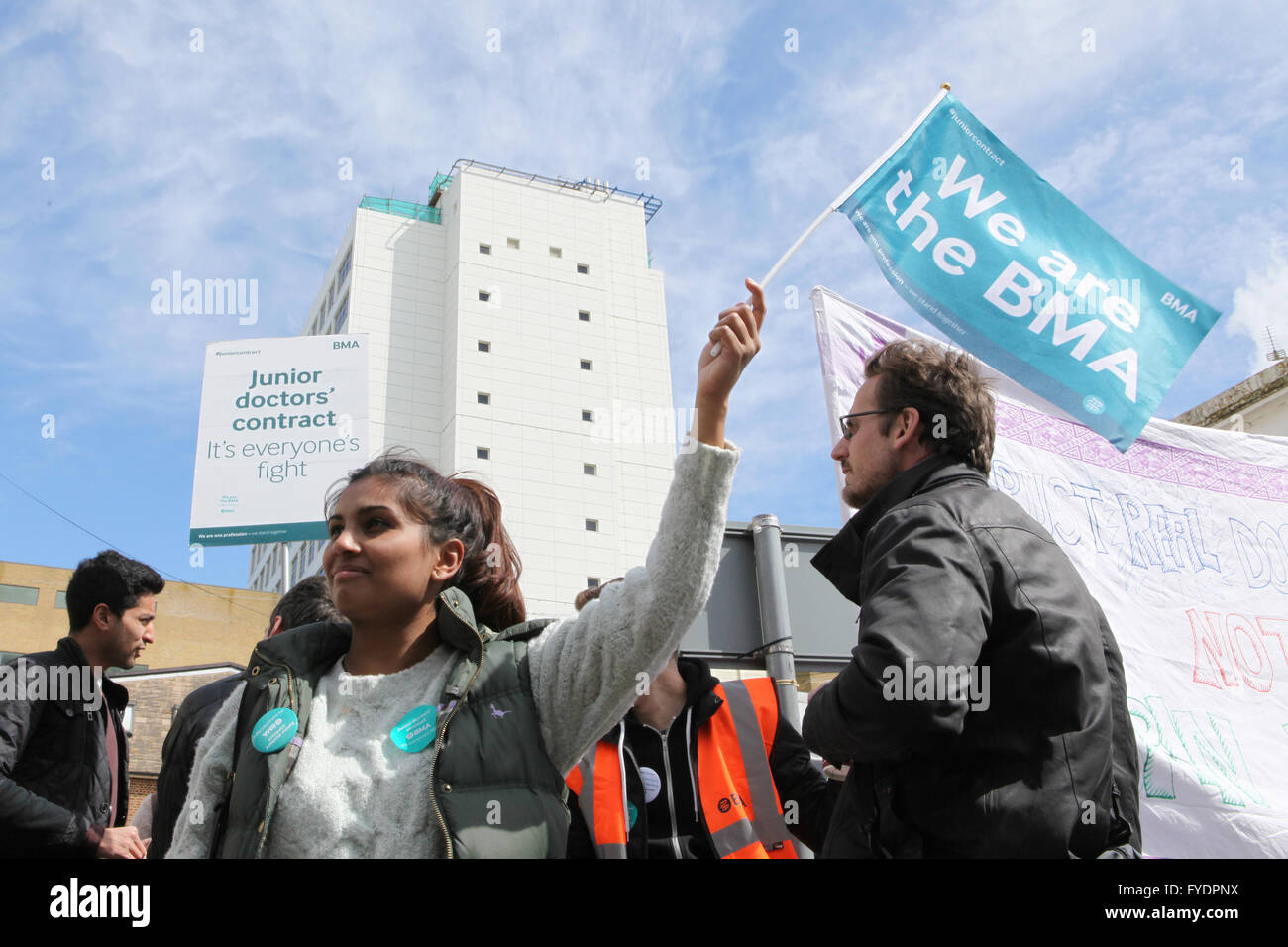 Brighton, UK. 26th April, 2016. Maddie Shrotri, a 24-year-old junior doctor, protests outside the Royal Sussex County Hospital in Brighton as thousands of junior doctors across England stage a historic all-out strike by walking out of both routine and emergency care in protest at the imposition of a new work contract. Credit:  Randi Sokoloff/Alamy Live News Stock Photo