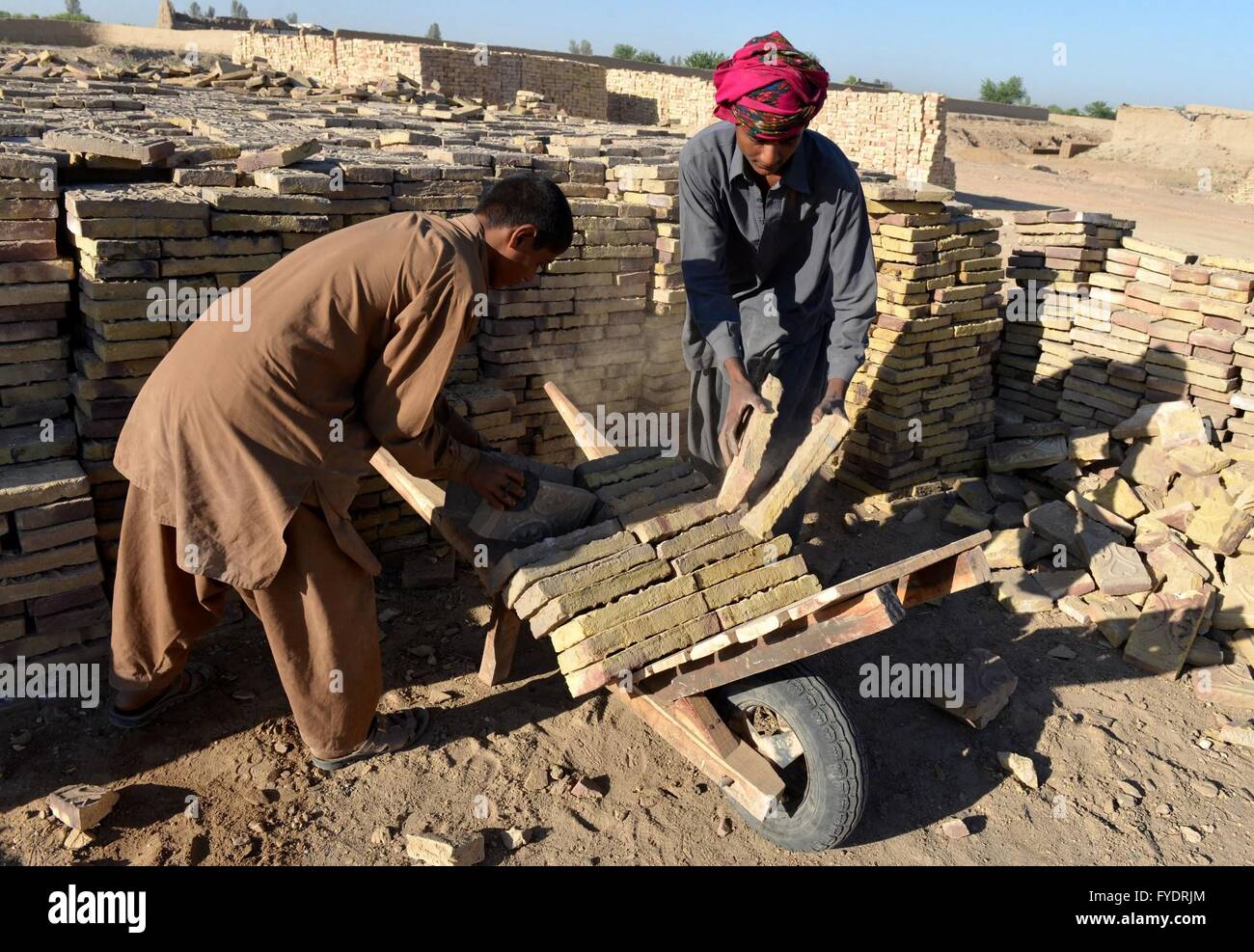 Kandahar, Afghanistan. 26th Apr, 2016. Afghan men load bricks on a hand ...