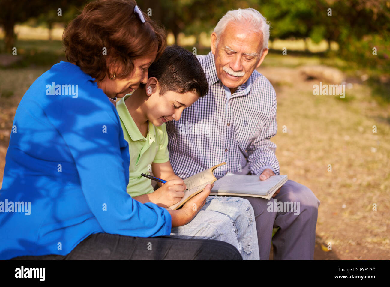 Grandparents educating grandson: Senior woman and old man spending time with their grandchild in park. The old people help the p Stock Photo