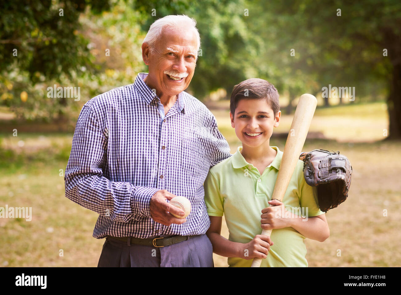 Grandpa spending time with grandson: Portrait of senior man playing baseball  with his grandchild in park. The old man embraces t Stock Photo - Alamy