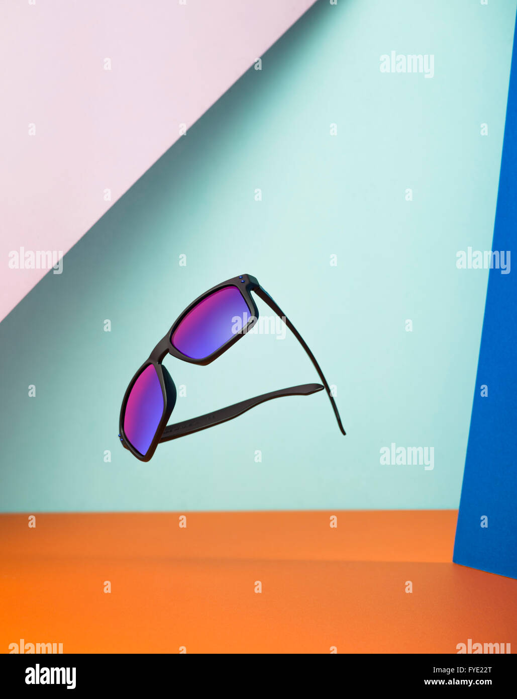 creative shot of a floating pair of Oakley Sunglasses against multiple colours Stock Photo