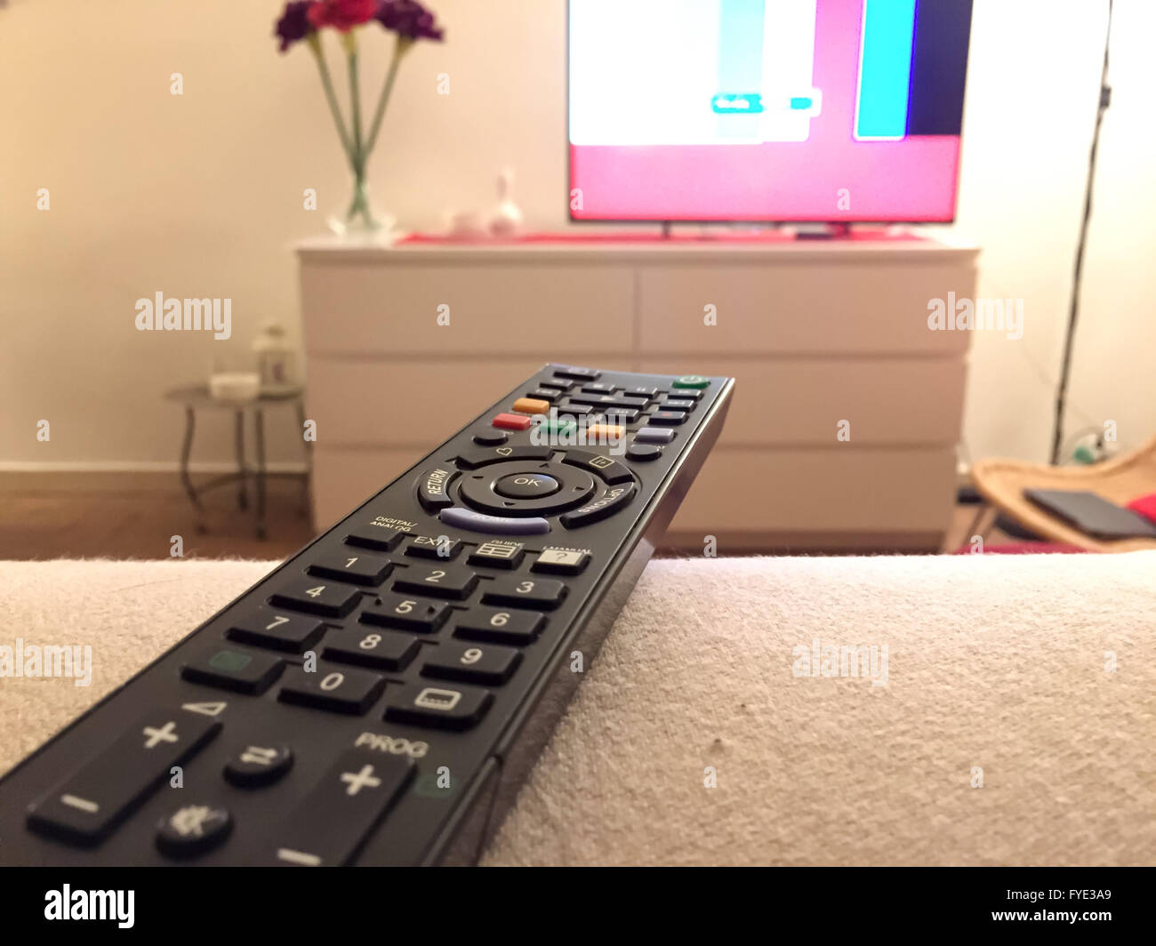 Close up of a remote controller with a television on background Stock Photo