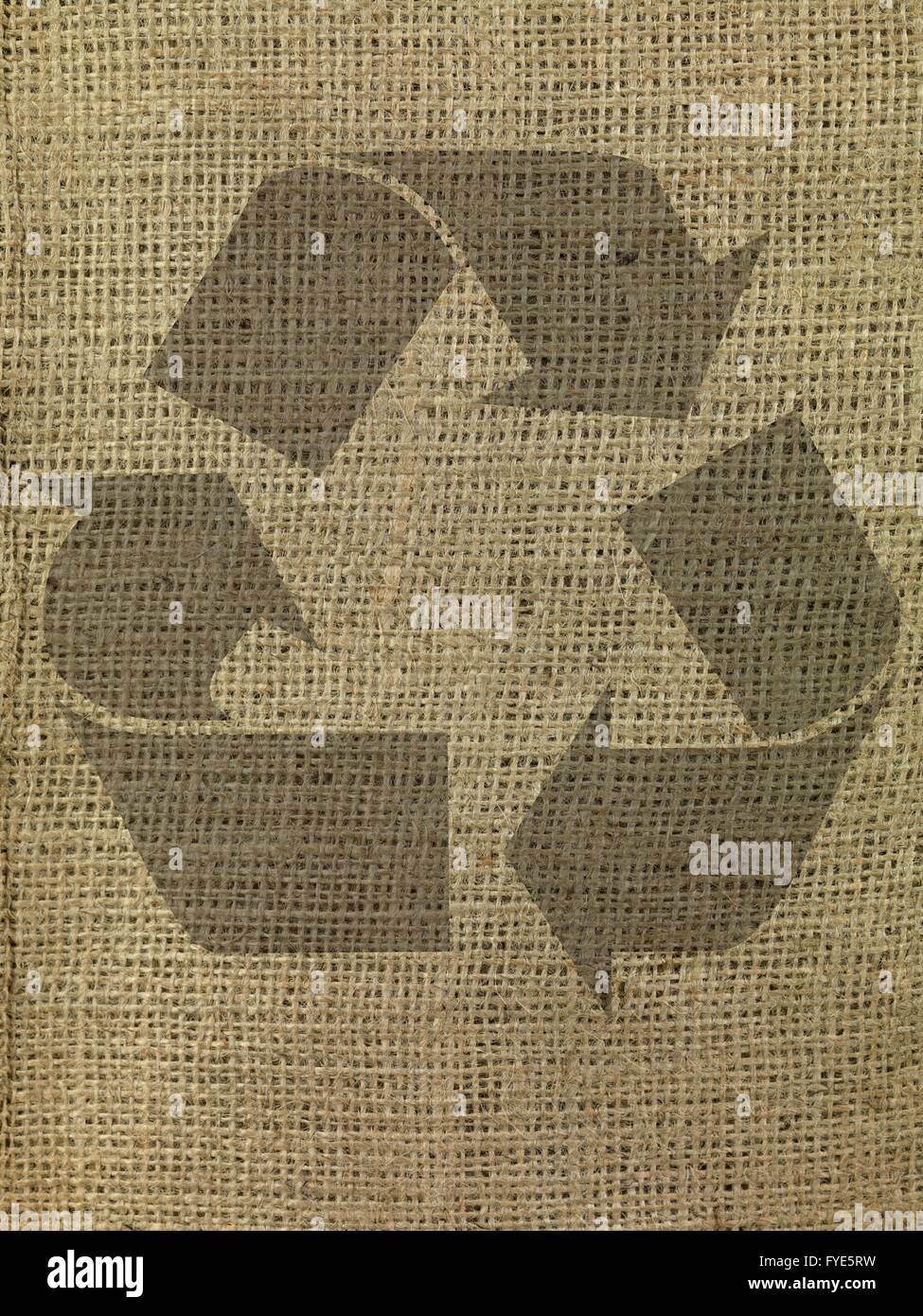 A close up shot of brown hessian cloth with a recycle symbol Stock