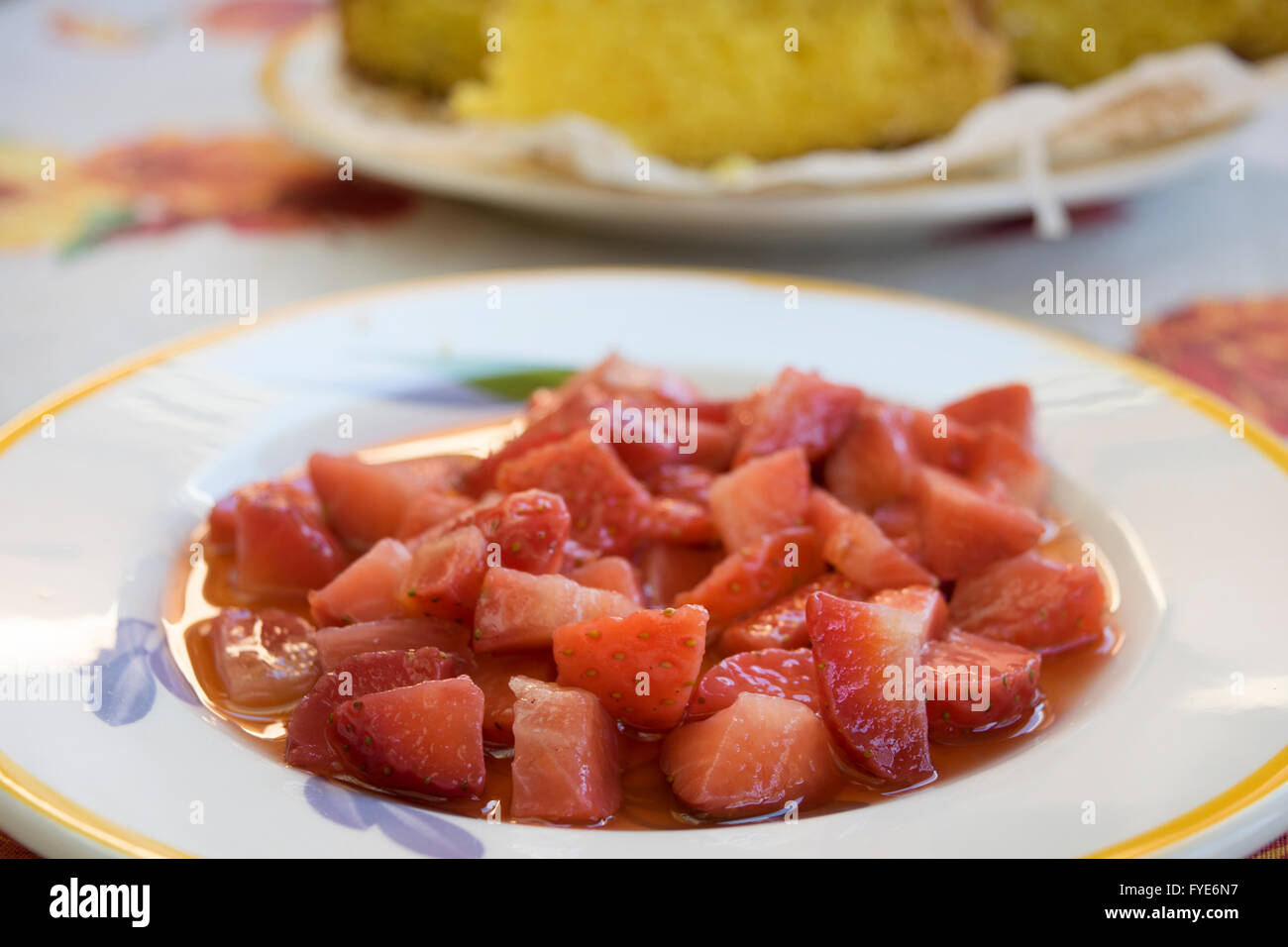 chopped strawberries in a dish with a  sponge cake Stock Photo