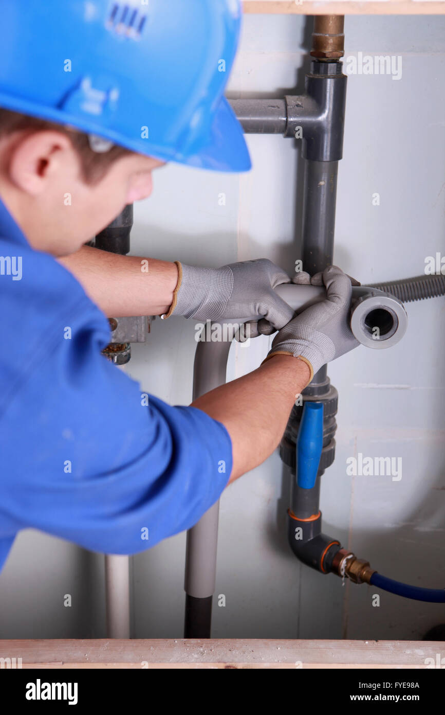 Plumber installing plastic domestic water pipes Stock Photo