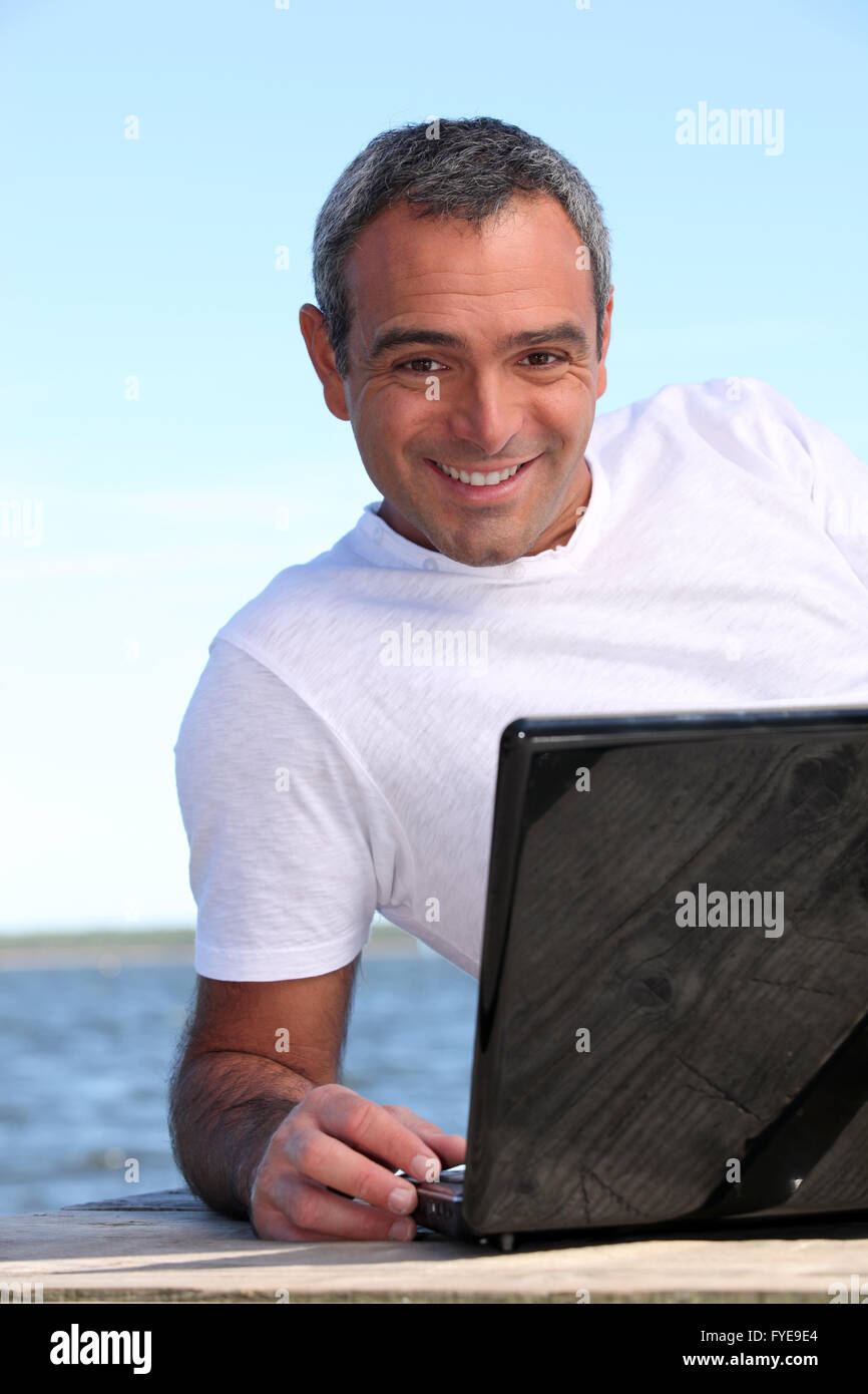 40 years old man doing computer behind the sea Stock Photo Alamy