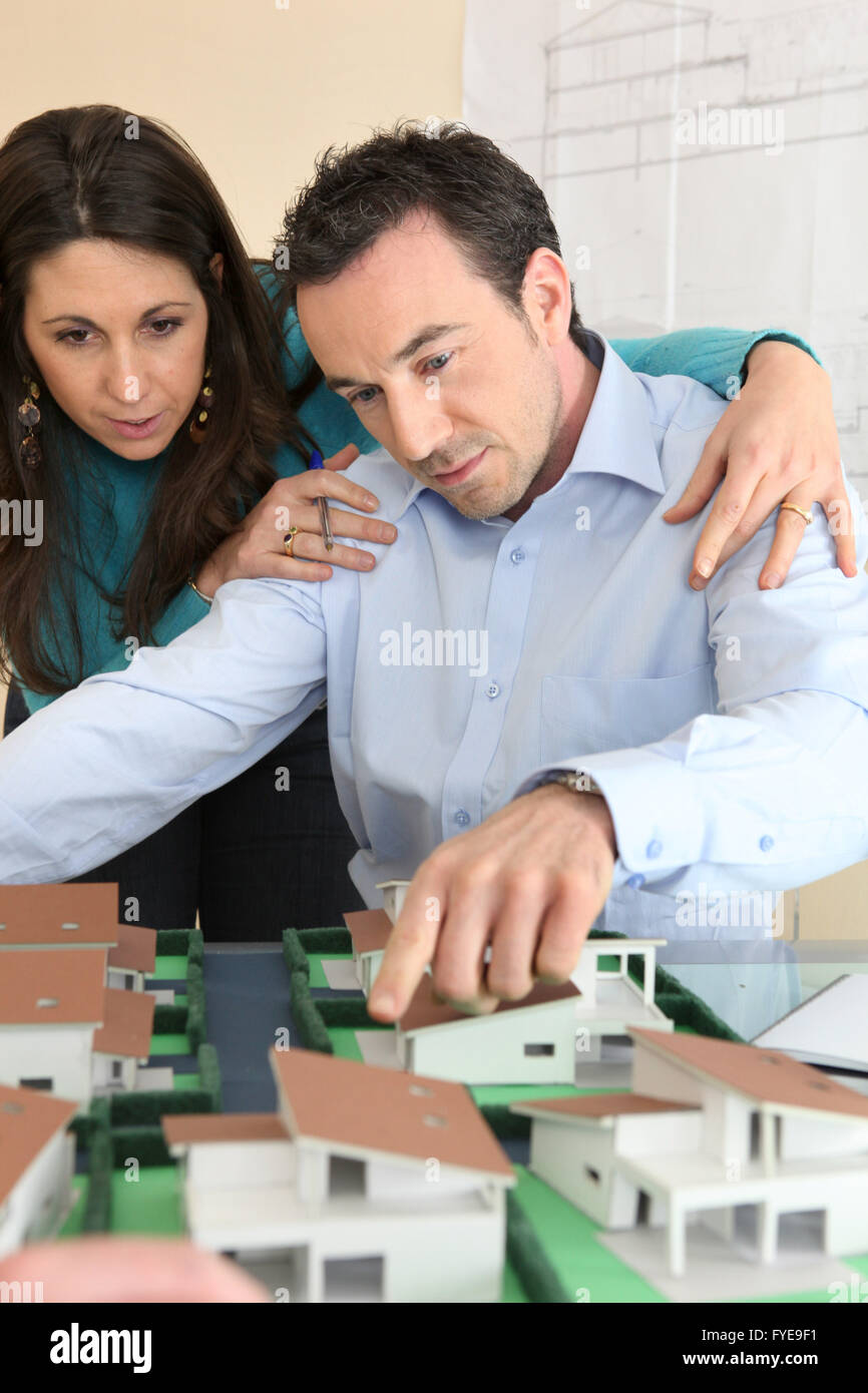 Architect and assistant gathered around model housing Stock Photo