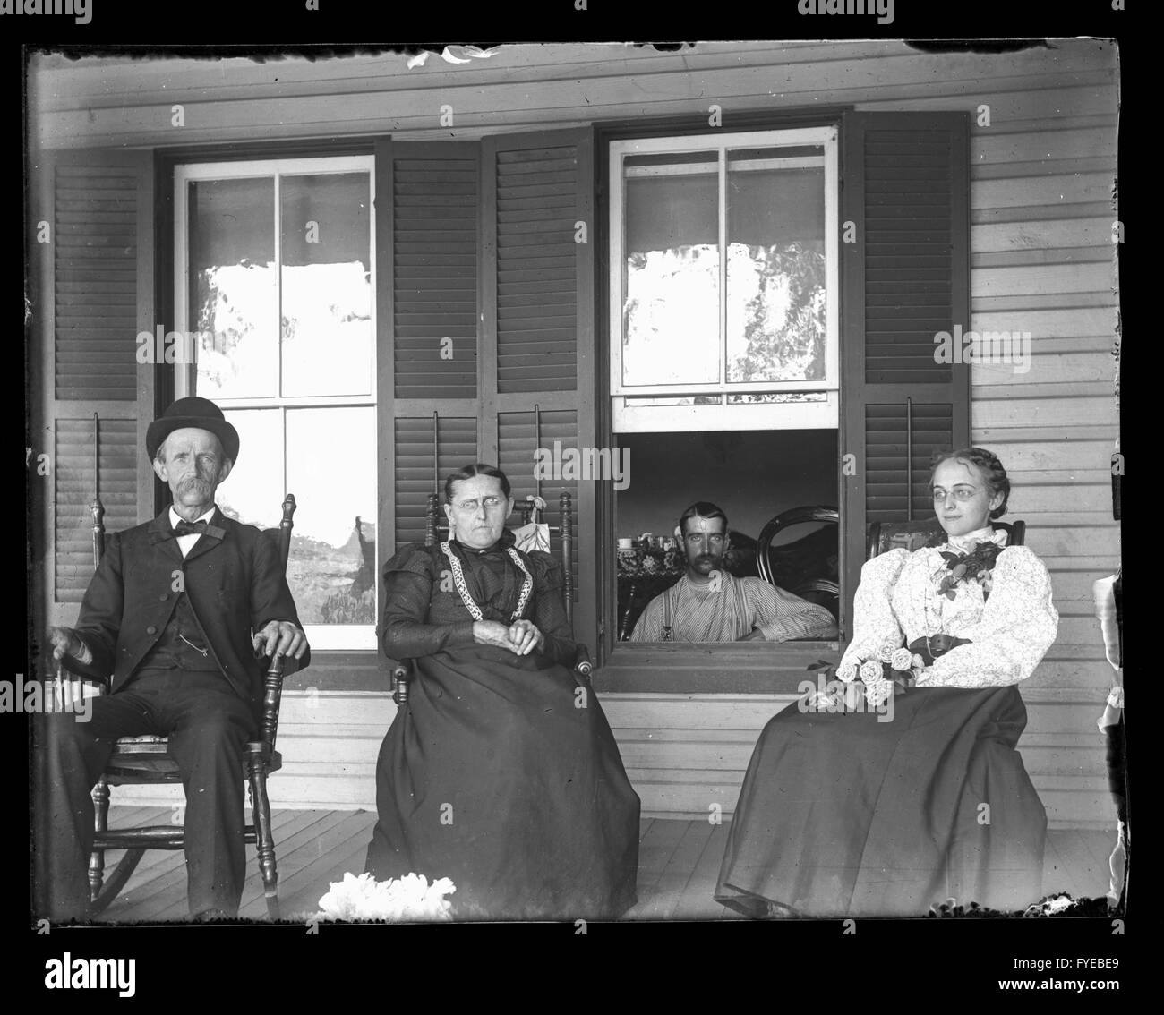 Victorian photograph of family members on the porch of their house in