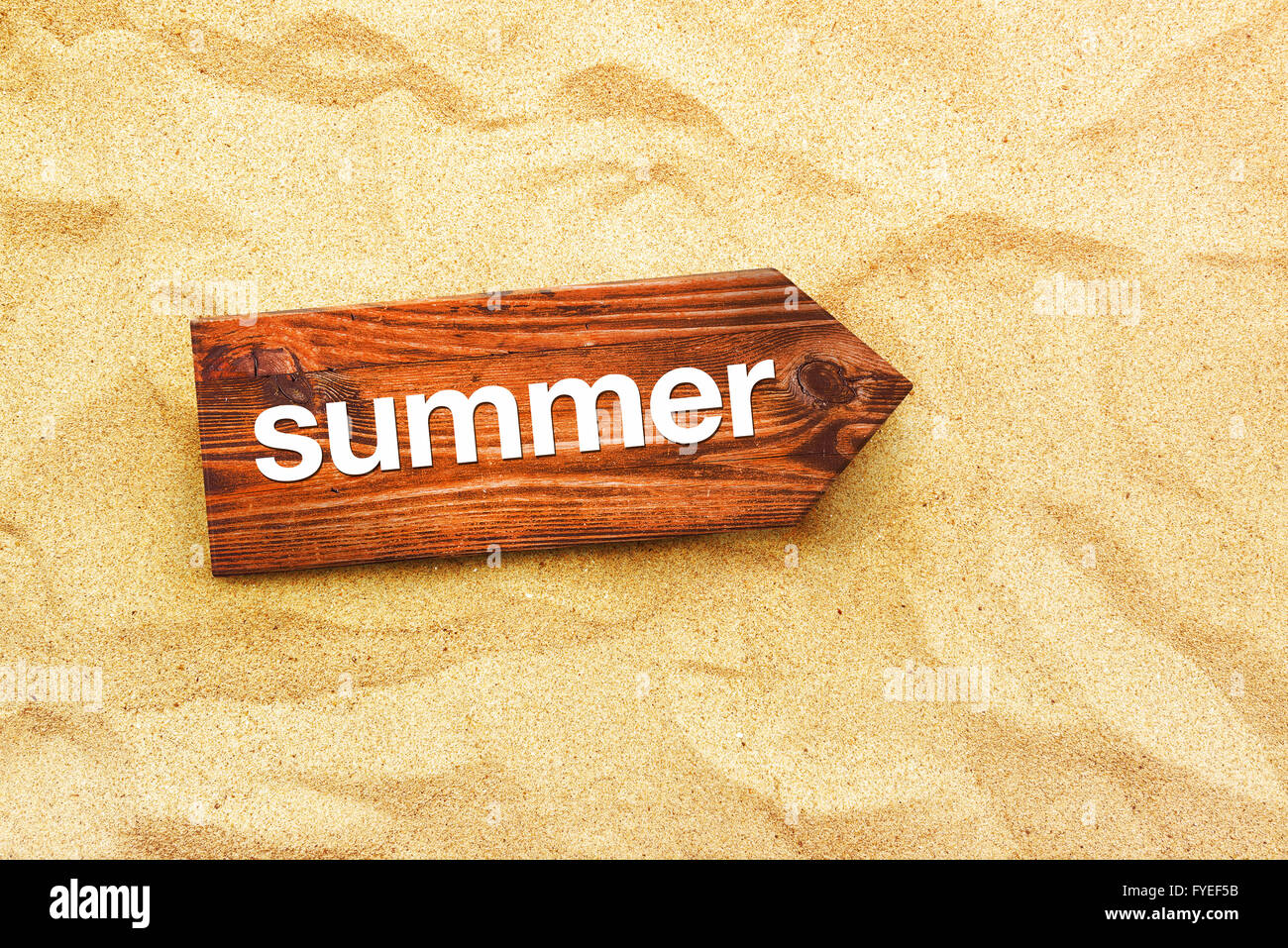 Summer direction sign in warm beach sand, summertime holiday vacation top view Stock Photo