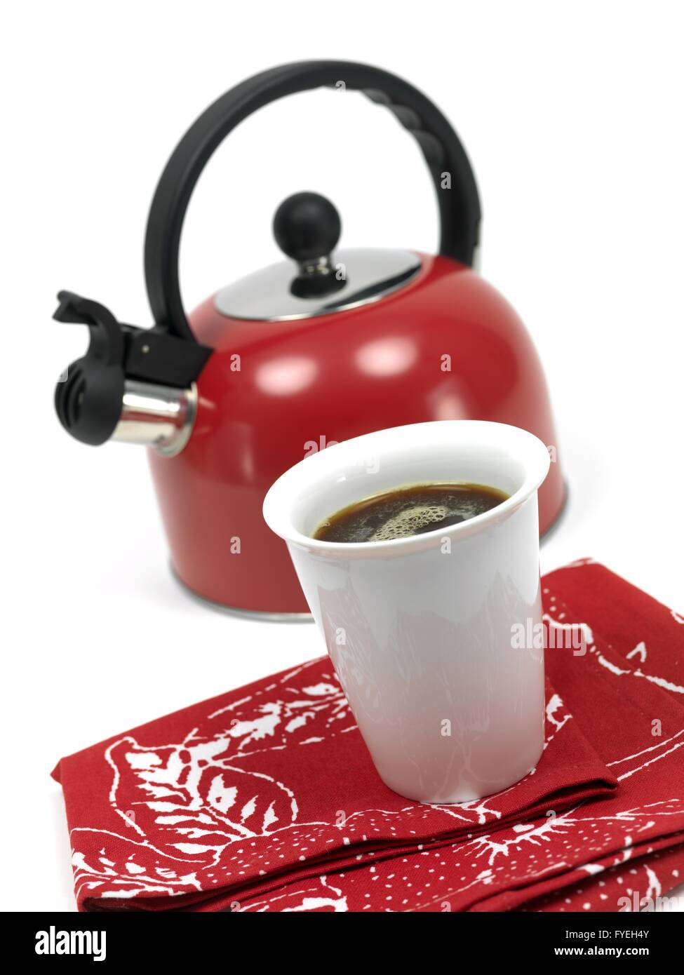 A stove top kettle and a cup of coffee on a kitchen bench Stock Photo