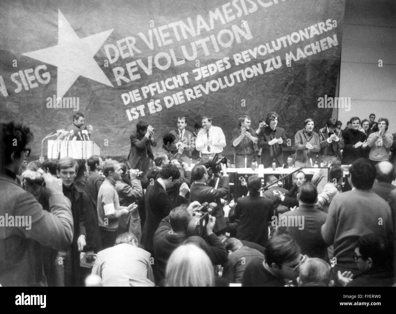 About 3000 persons, mostly students, took part in the International Vietnam conference, carried out by the Socialist German Student Union (SDS), at the Technical University in Berlin on 17th February 1968. Following persons standing at the table in front of the outsized Vietcong flag: (l-r) K.D Wolff (at the speaker's desk), Dr Klaus Meschkat, Dr Johannes Agnoli, Christian Semmler, Gaston Salvatore, Rudi Dutschke, Günther Ament, Kurt Steinhaus and Tariq Ali. Stock Photo