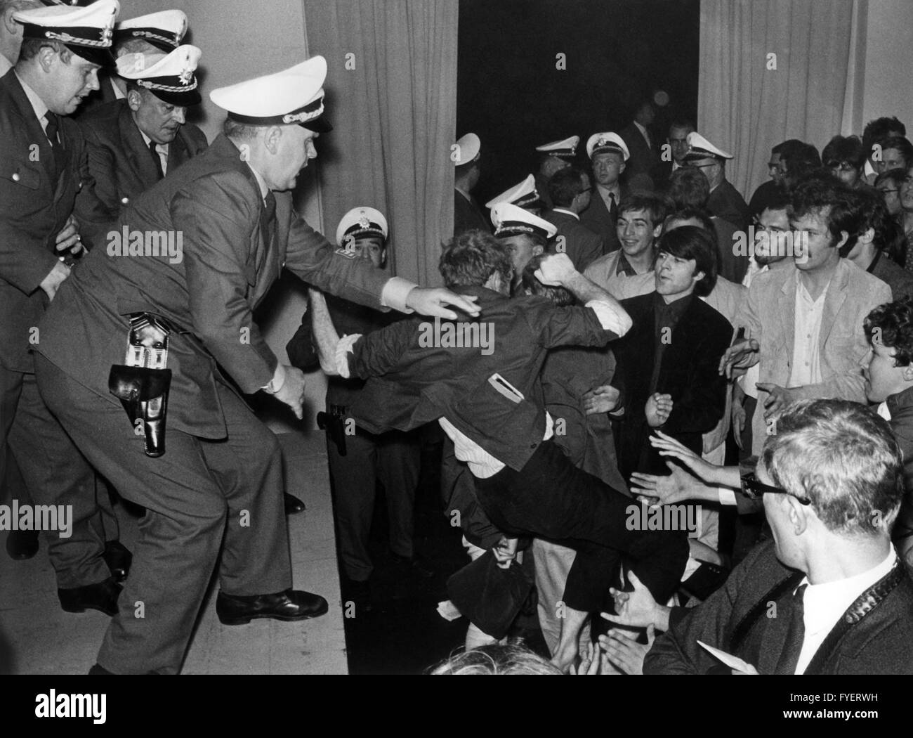 Policemen remove a demonstrant (m) during a discussion in the America House in Frankfurt on the 6th of September in 1967, who wanted to protest against the Vietnam politics of the US government. Stock Photo