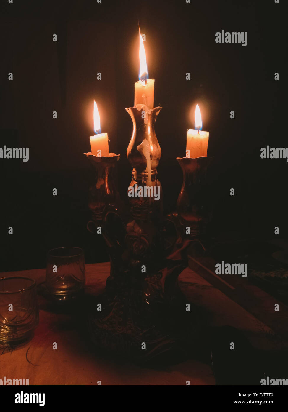 Candlestick in which three burning candles Stock Photo Alamy