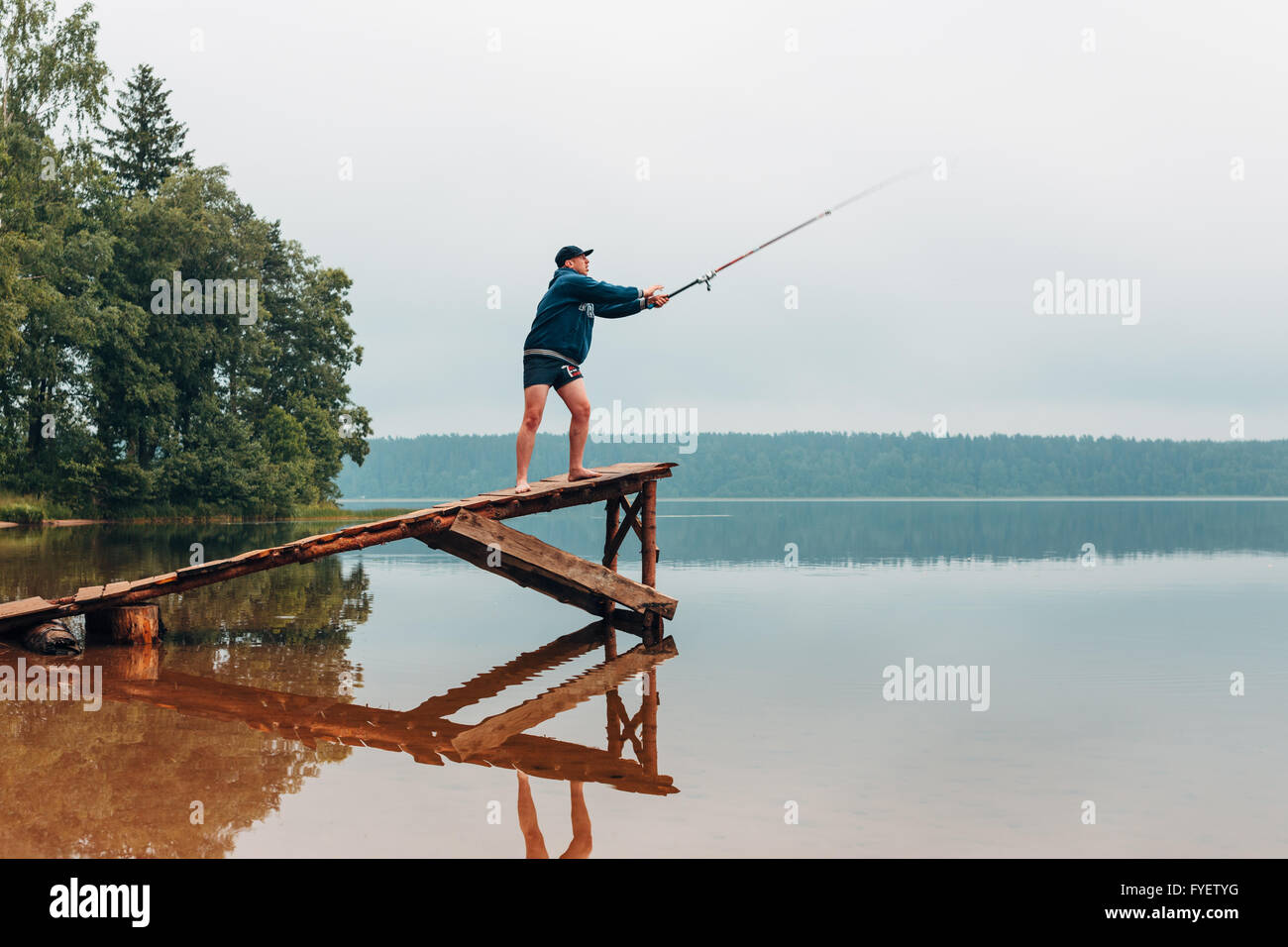 Man throws a fishing rod in the lake. Stock Photo