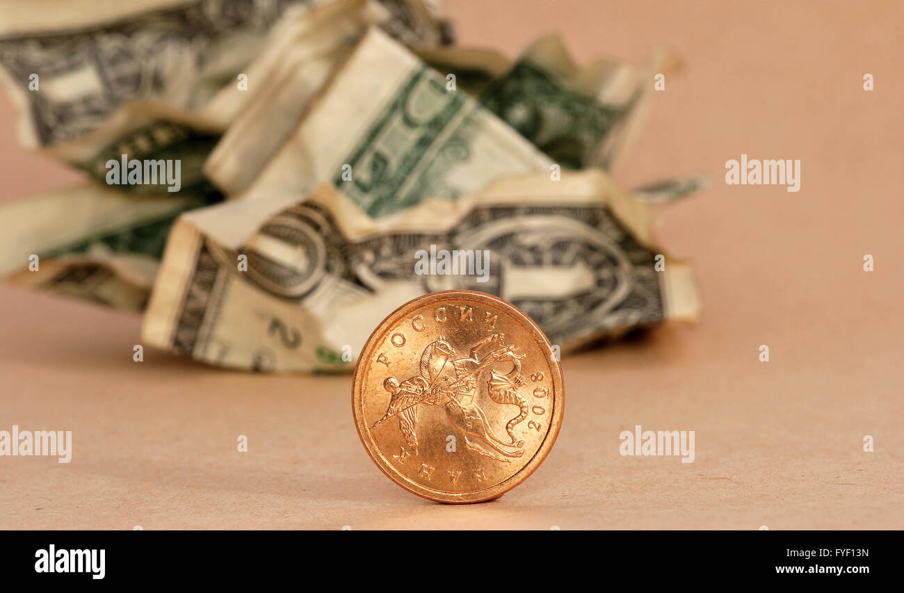golden coin and crumpled dollar Stock Photo