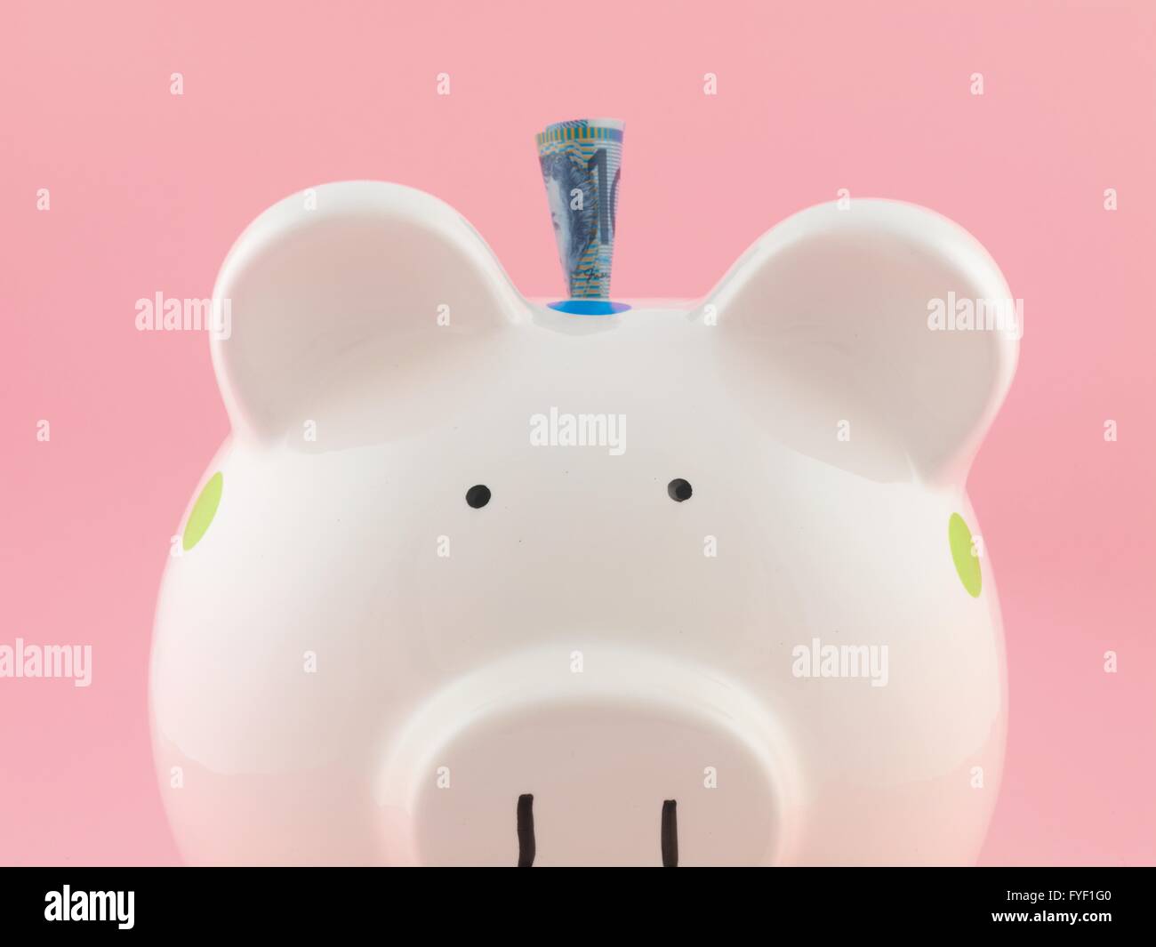 A piggy bank isolated against a pink background Stock Photo - Alamy