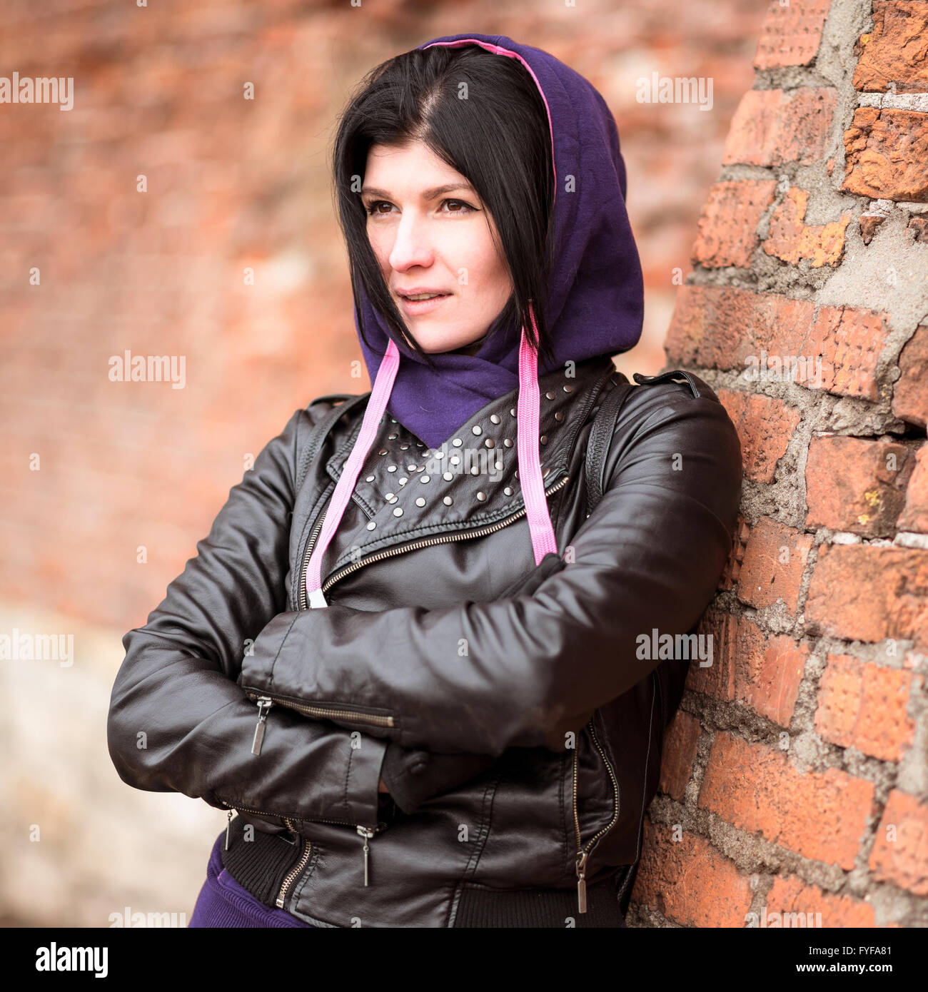Outdoors beautiful young brunette woman posing in a black leather Stock ...