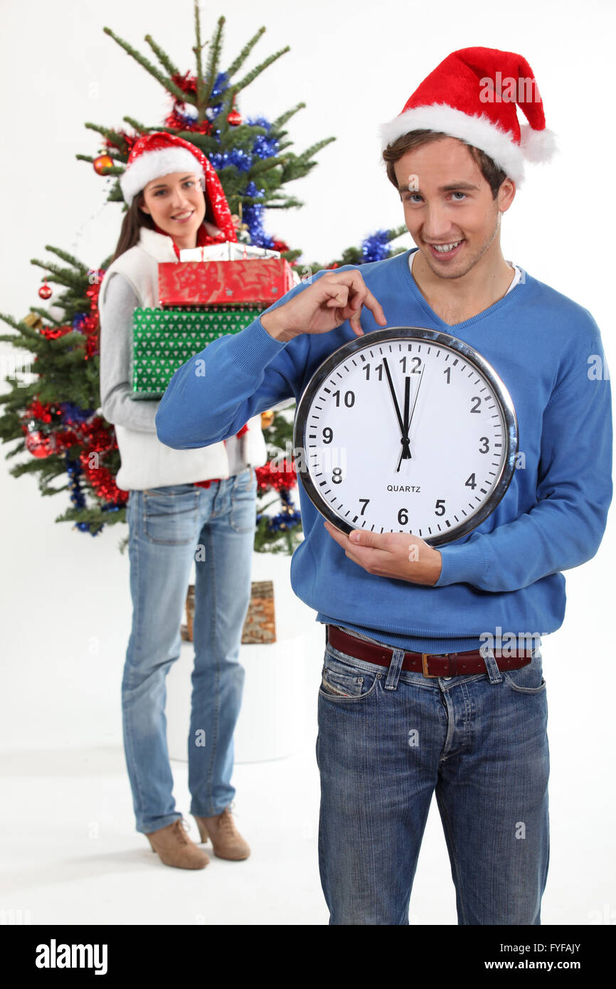 Couple eagerly waiting for Christmas Day to open presents Stock Photo