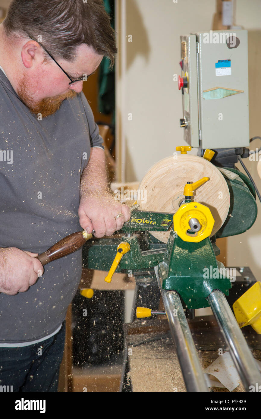 Woodturning craftsman at work turning wood on a woodturning lathe Stock