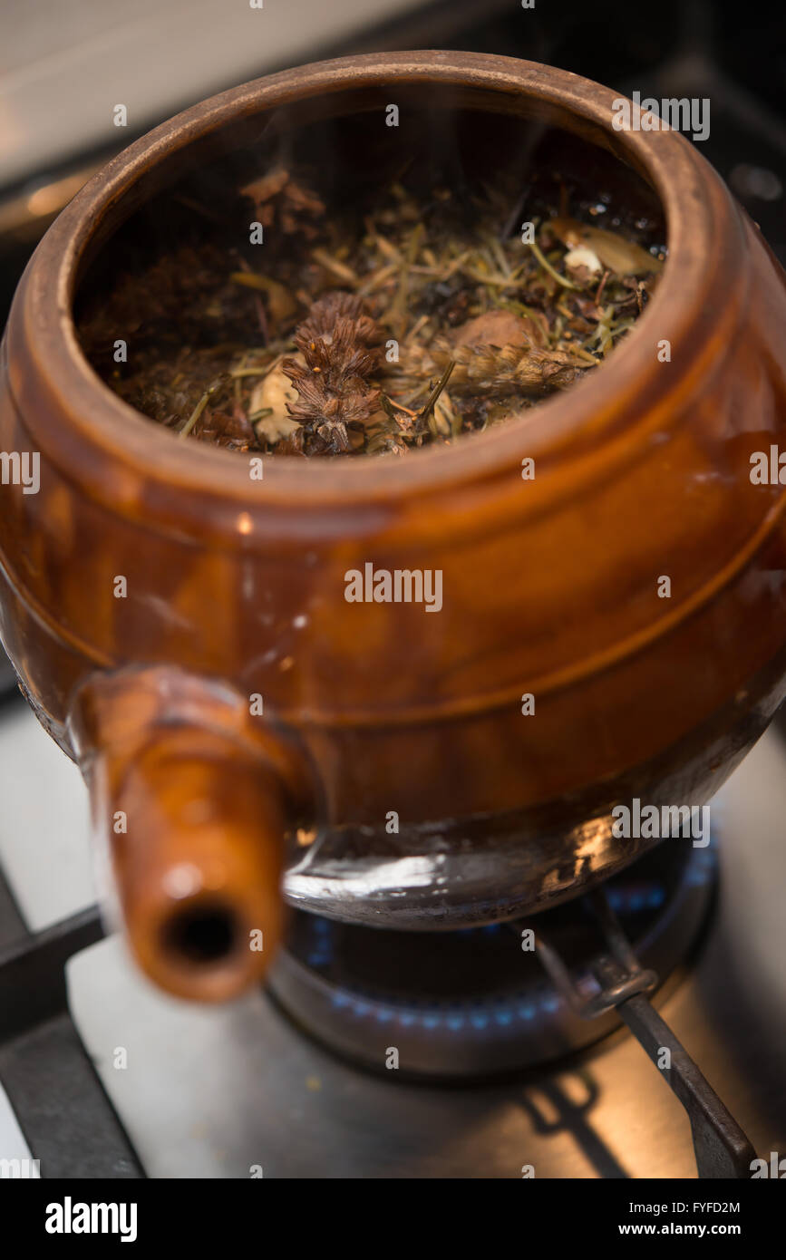 decocting medicinal herbs with enamel pot on gas burner Stock Photo
