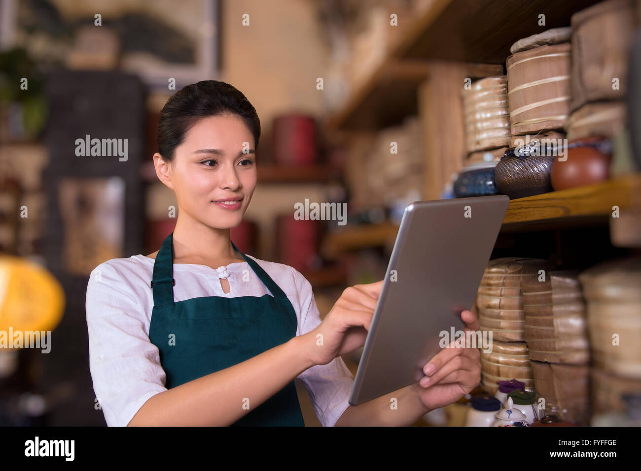 Tea house owner checking inventory using digital tablet Stock Photo