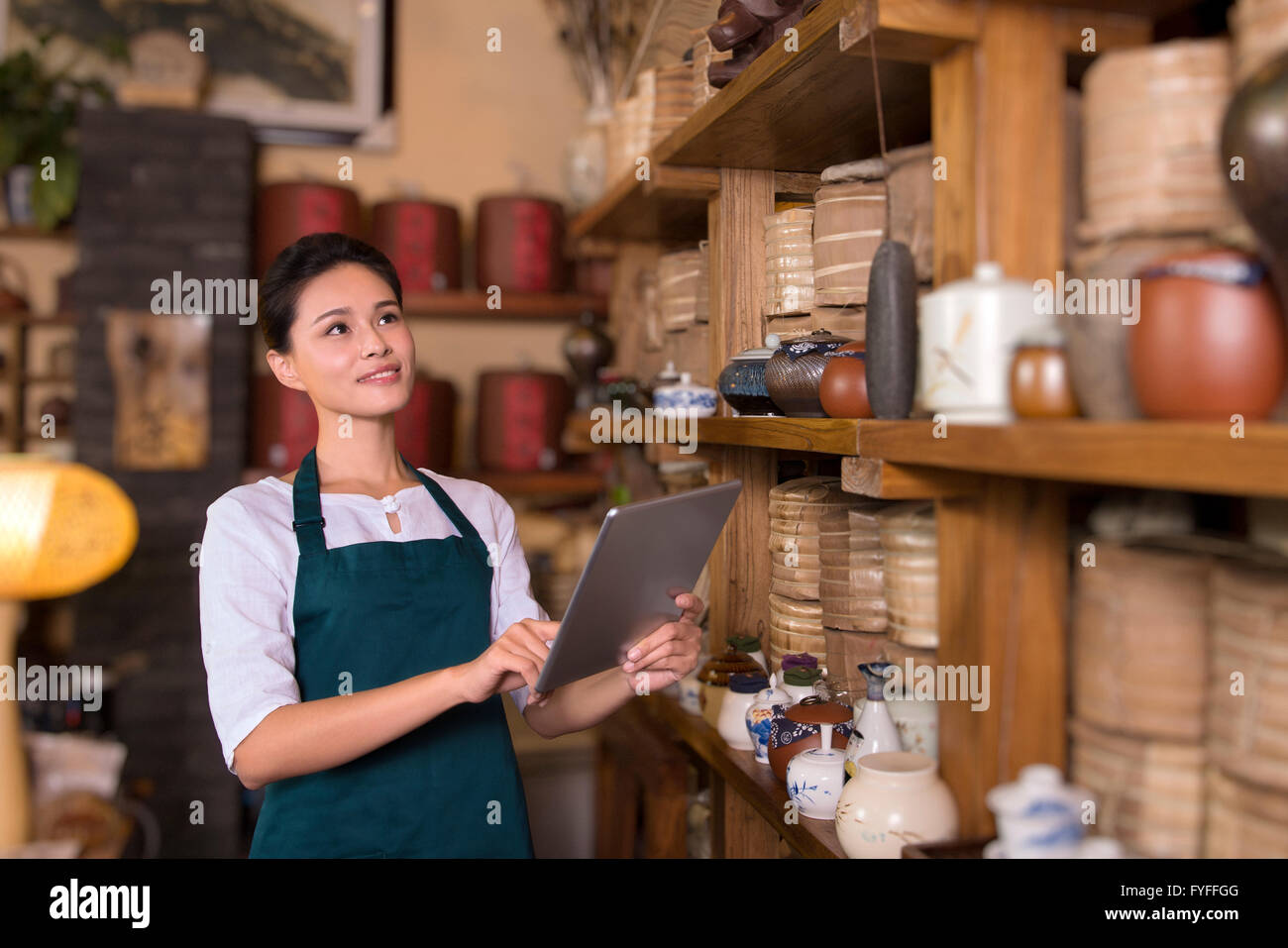 Tea house owner checking inventory using digital tablet Stock Photo