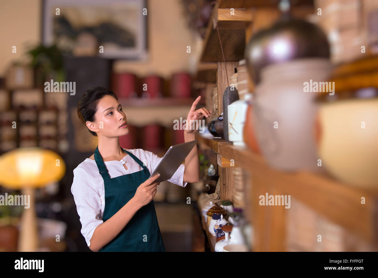 Tea house owner checking inventory using digital tablet Stock Photo