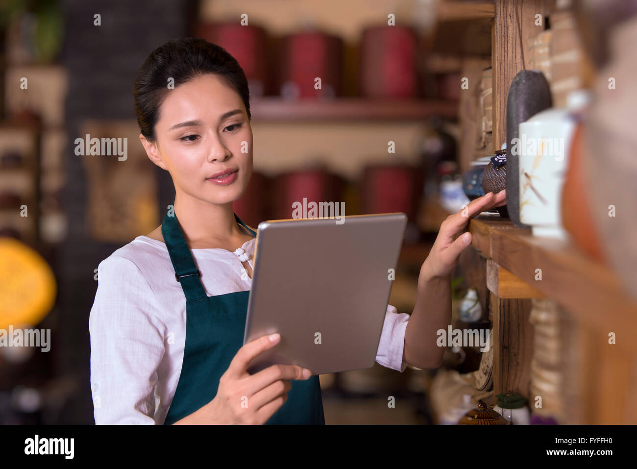 Tea house owner checking inventory using digital tablet Stock Photo