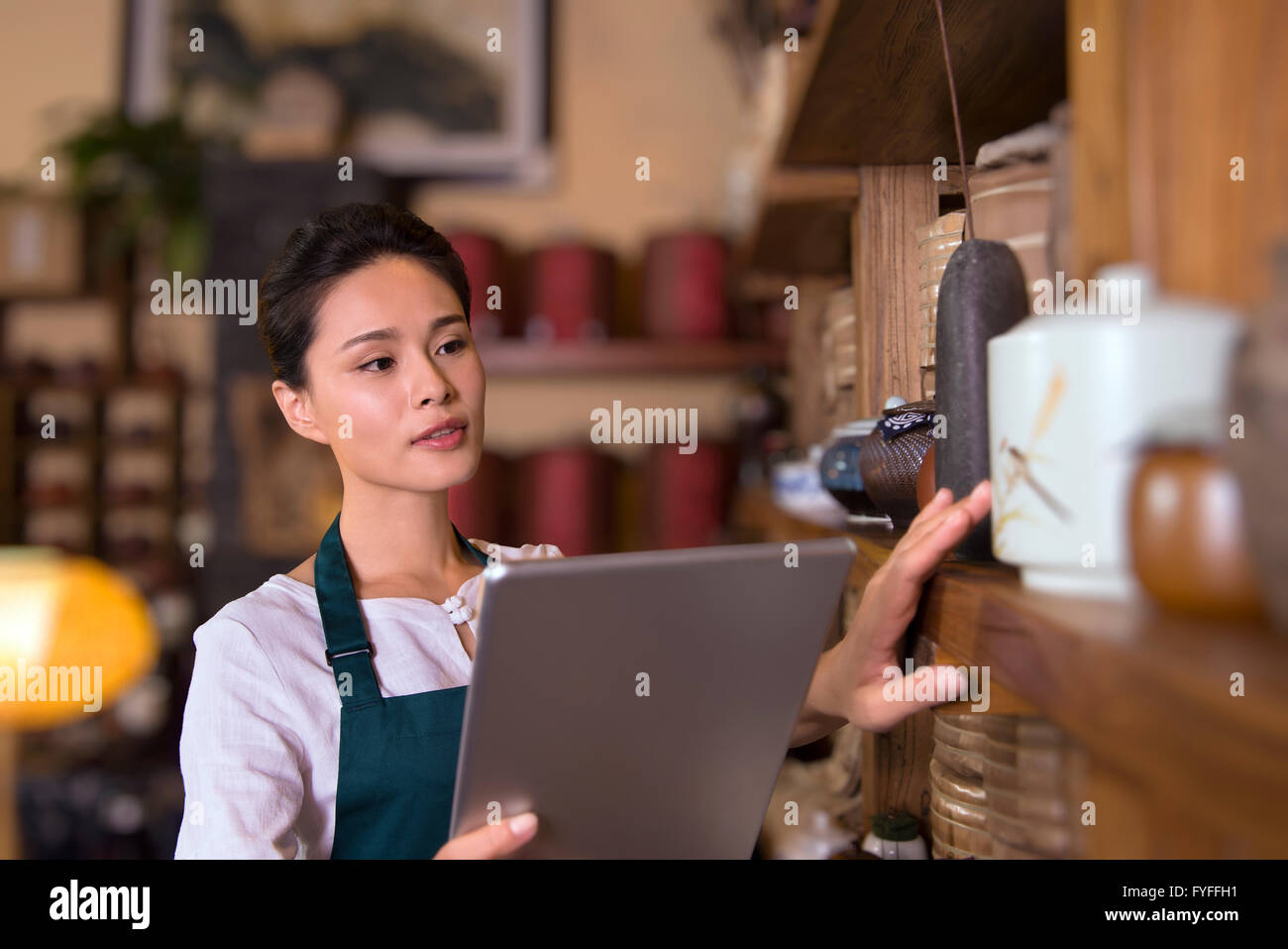 Tea house owner checking inventory using digital tablet Stock Photo