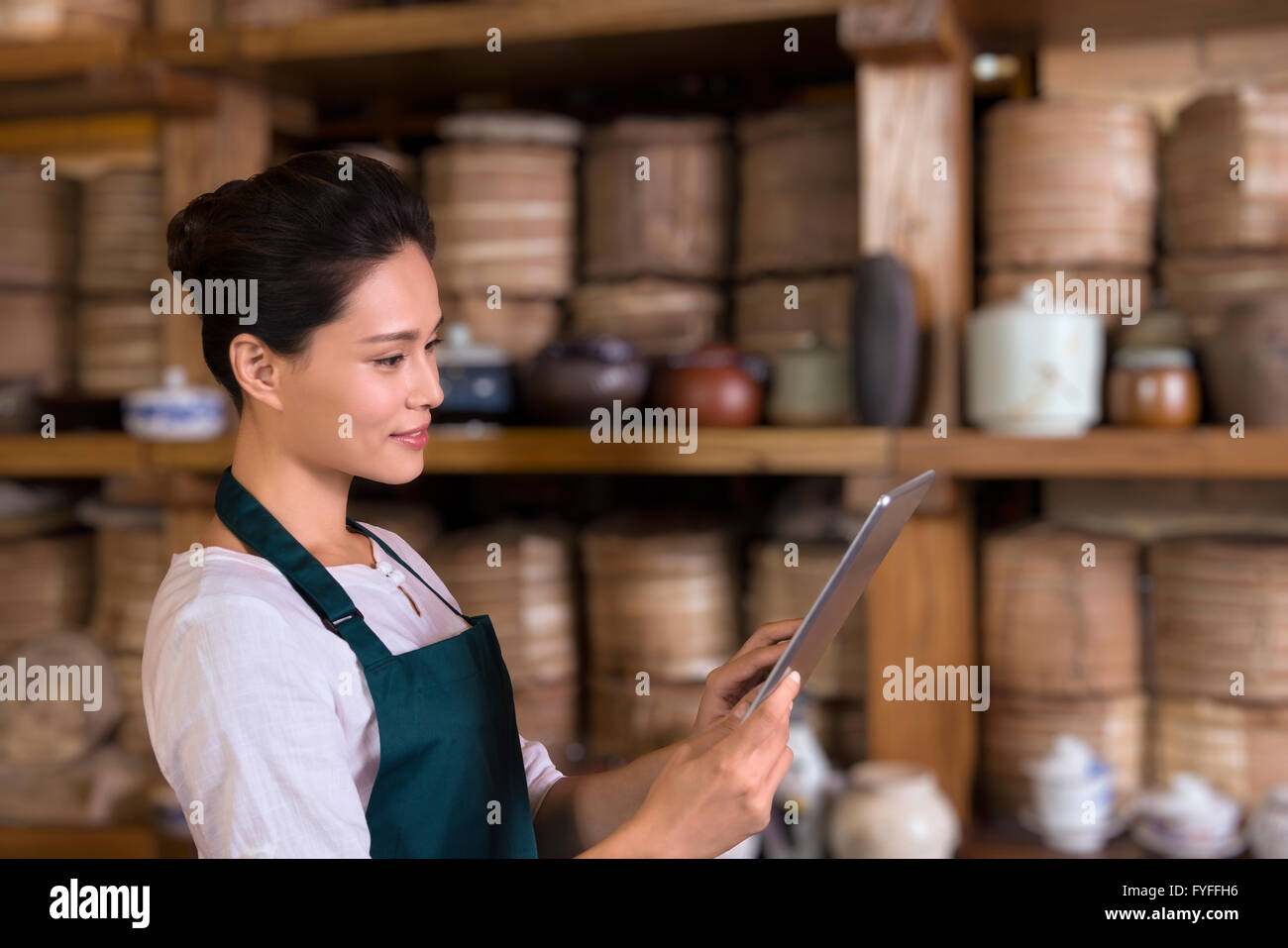 Tea house owner checking inventory using digital tablet Stock Photo