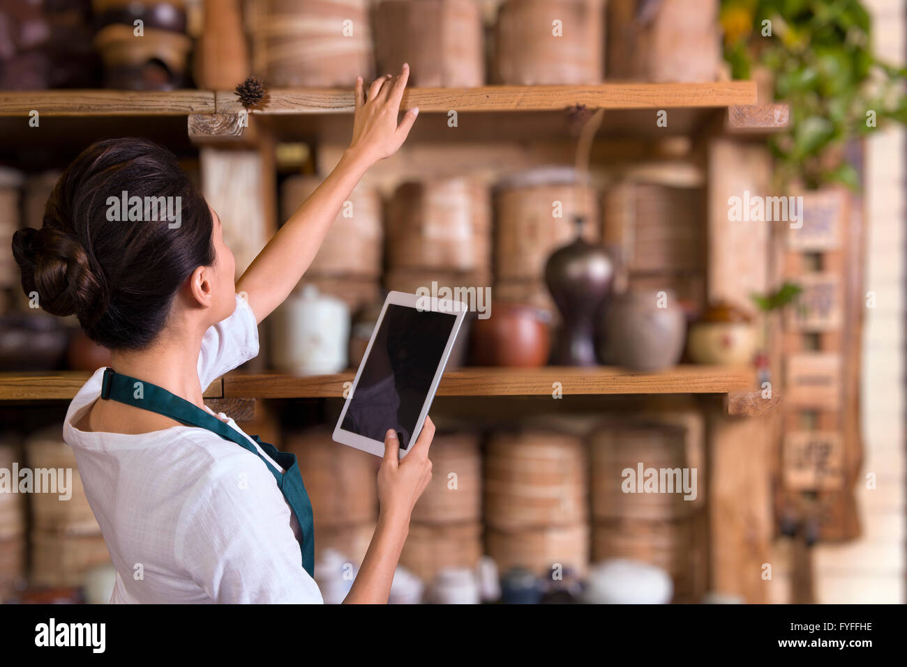 Tea house owner checking inventory using digital tablet Stock Photo