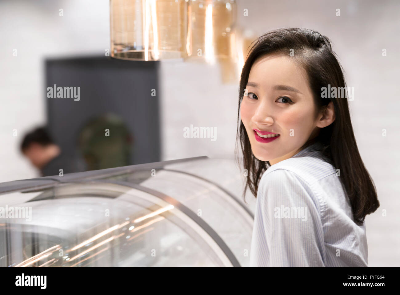 Shopkeeper in front of display cabinet in bakery Stock Photo