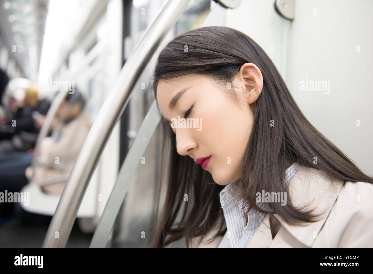 Businesswoman falling asleep in subway Stock Photo