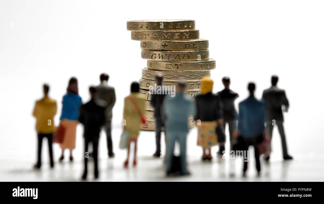 Crowdfunding concept. A crowd of people standing in front of a stack of one pound coins. Stock Photo