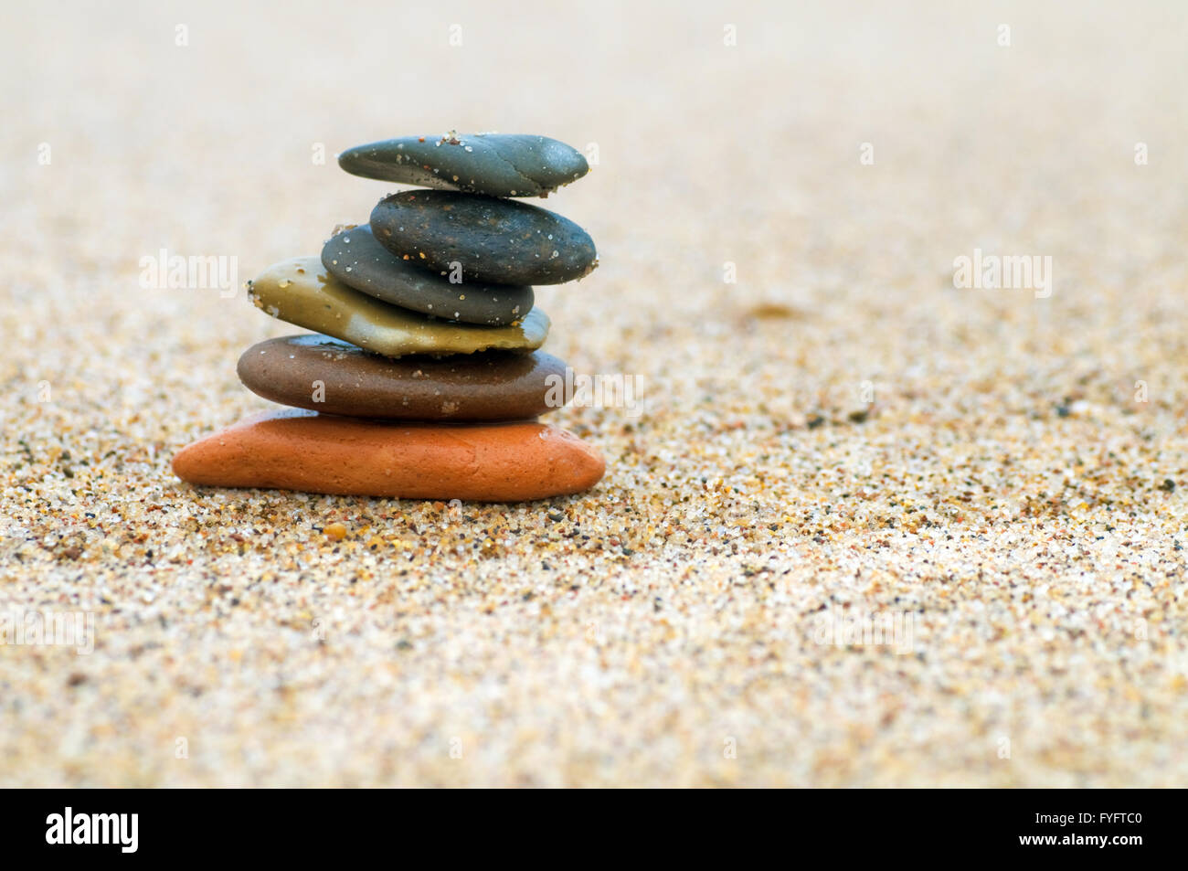 Stack of beach stones on sand. Harmony Stock Photo