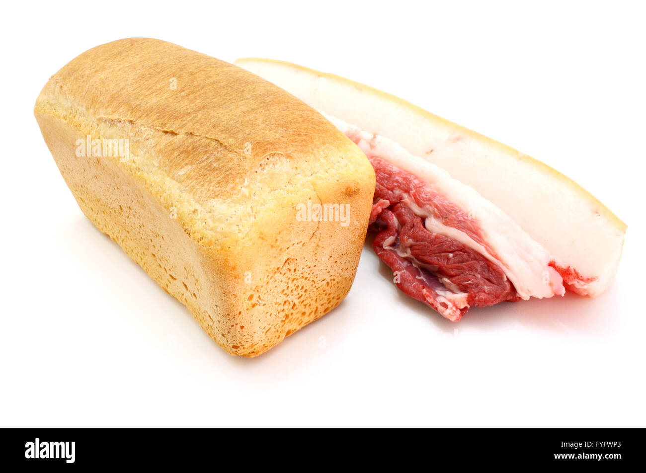 Roll of fresh bread and the big piece of fat with meat Stock Photo