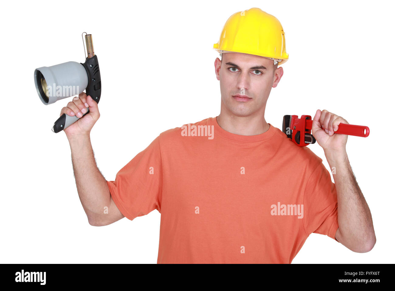 Tradesman holding a pipe wrench and a blowtorch Stock Photo Alamy
