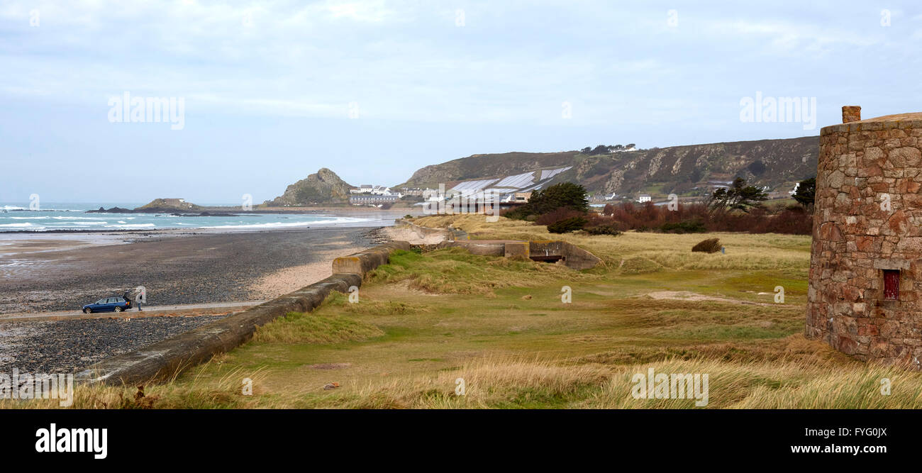 View along beach showing house 'hidden' within dunes and WW2 sea defences in foreground. Le Petit Fort, St Helier, United Kingdom. Architect: Hudson Architects, 2016. Stock Photo