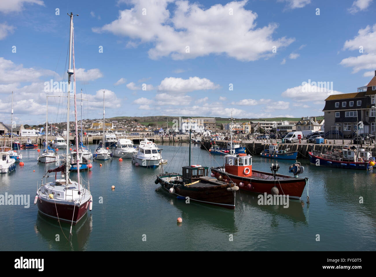 Yachts and fishing boats in West Bay harbour, Bridport, Dorset Stock Photo