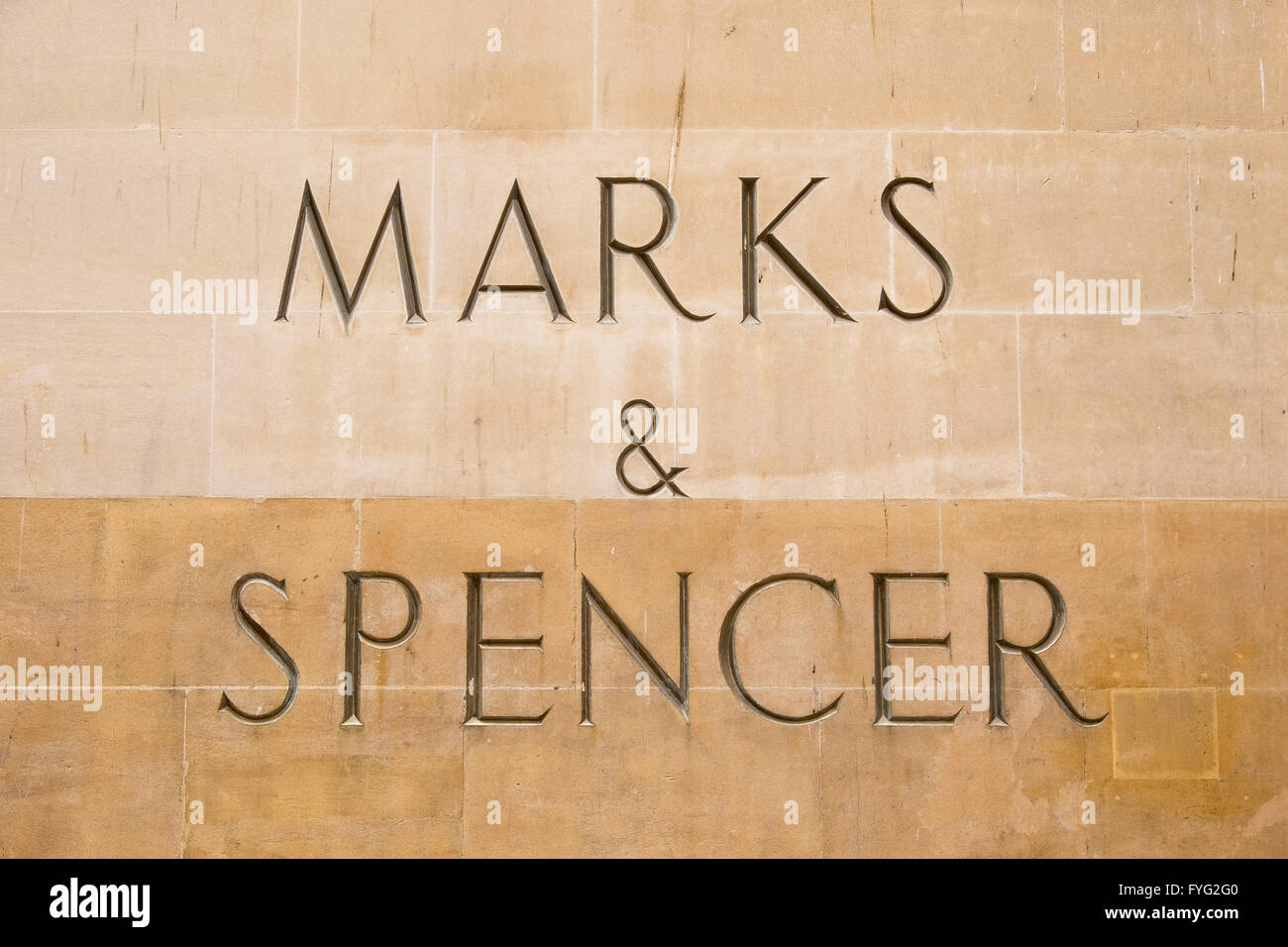 Marks and Spencer sign carved into stone on the side of a shop in Bath Stock Photo