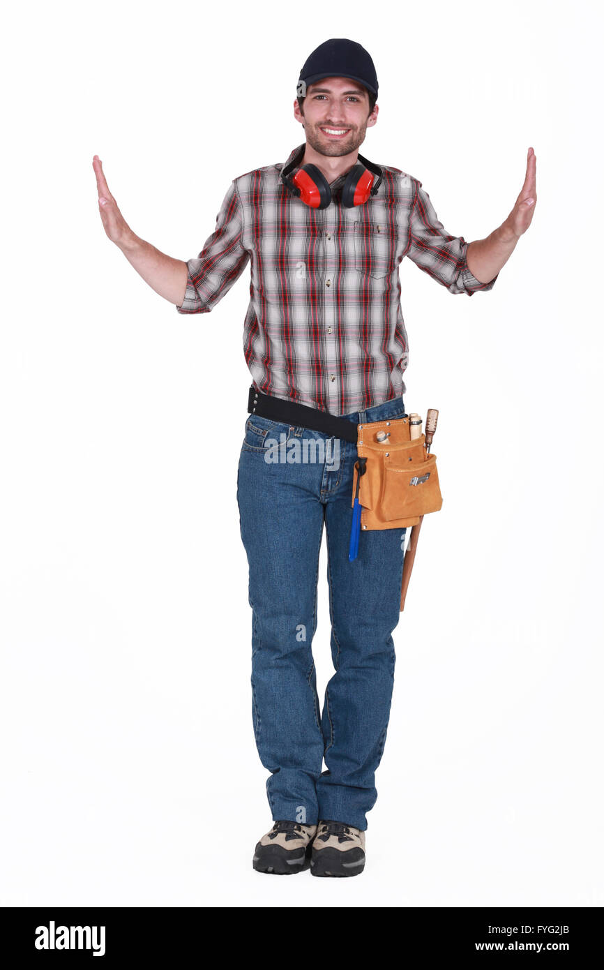 portrait of handsome carpenter wearing cap with hands raised on either side Stock Photo
